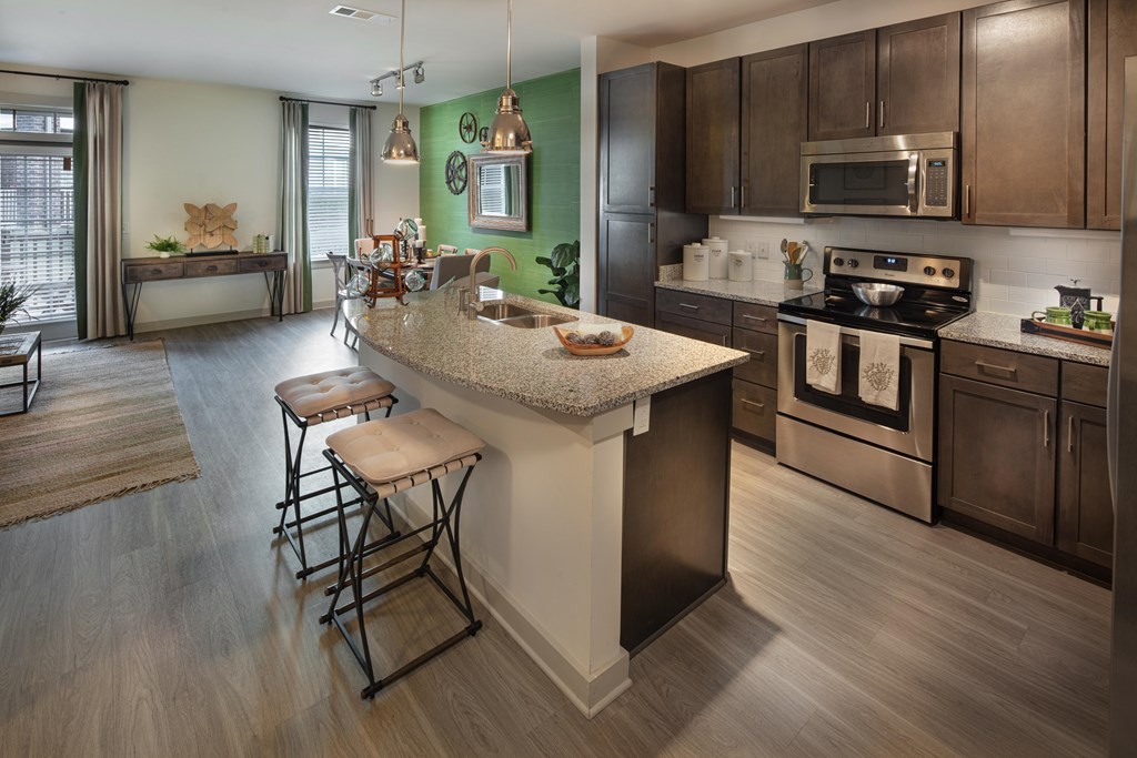 Vestavia Reserve kitchen with a granite counter top and stainless steel appliances. kitchen with a white island and dark wood cabinets.