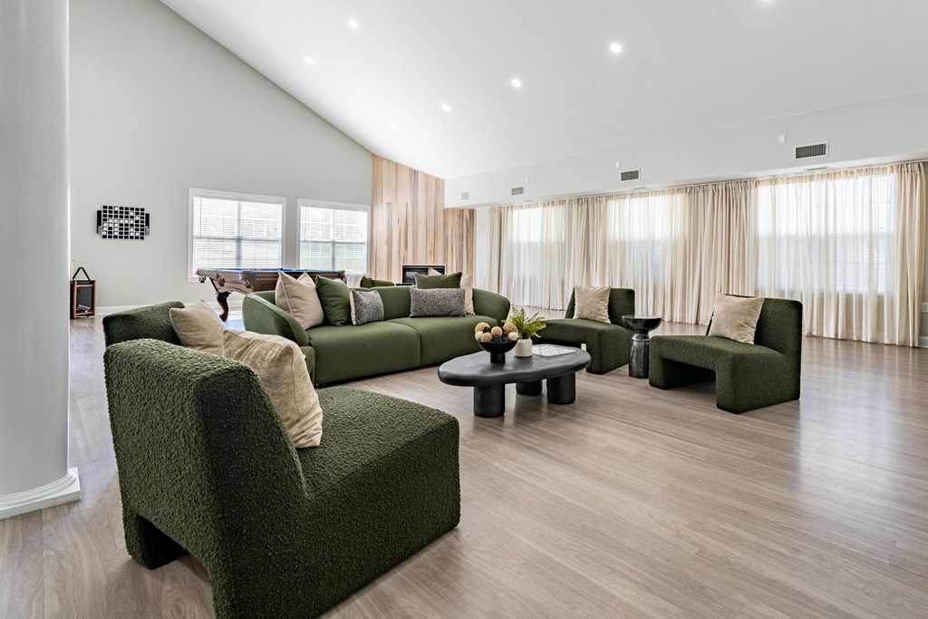 a living room with green couches and chairs