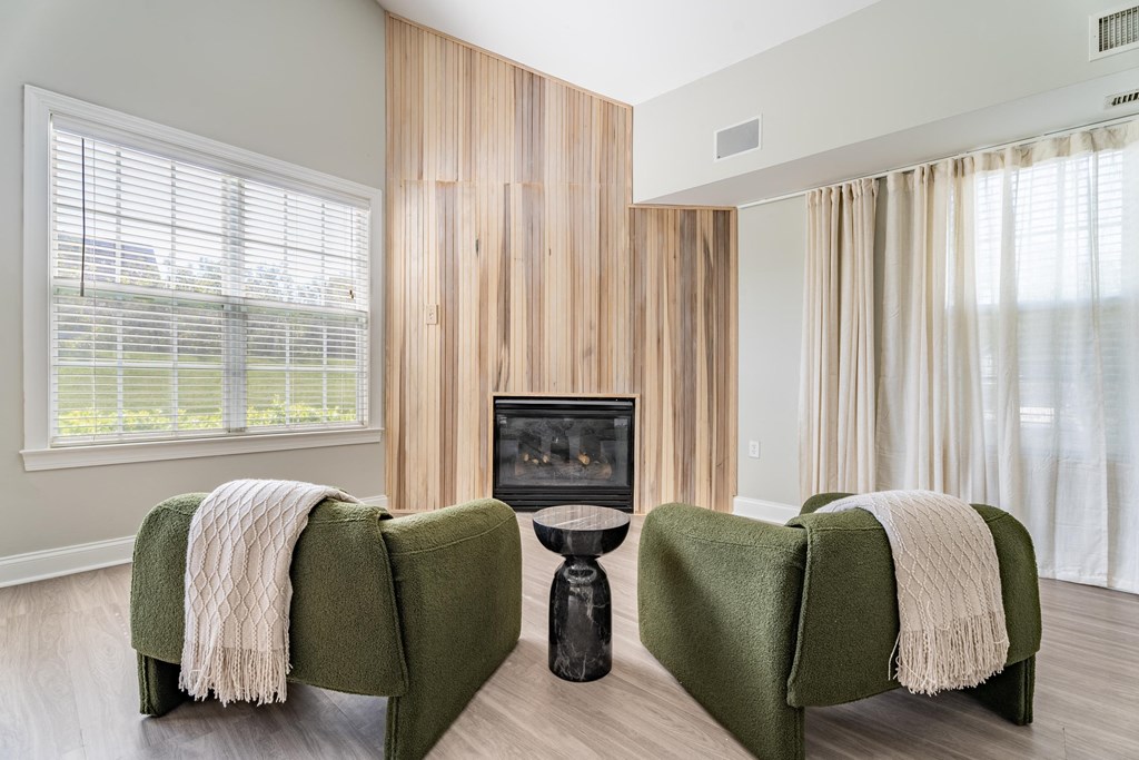 a living room with two green chairs and a fireplace