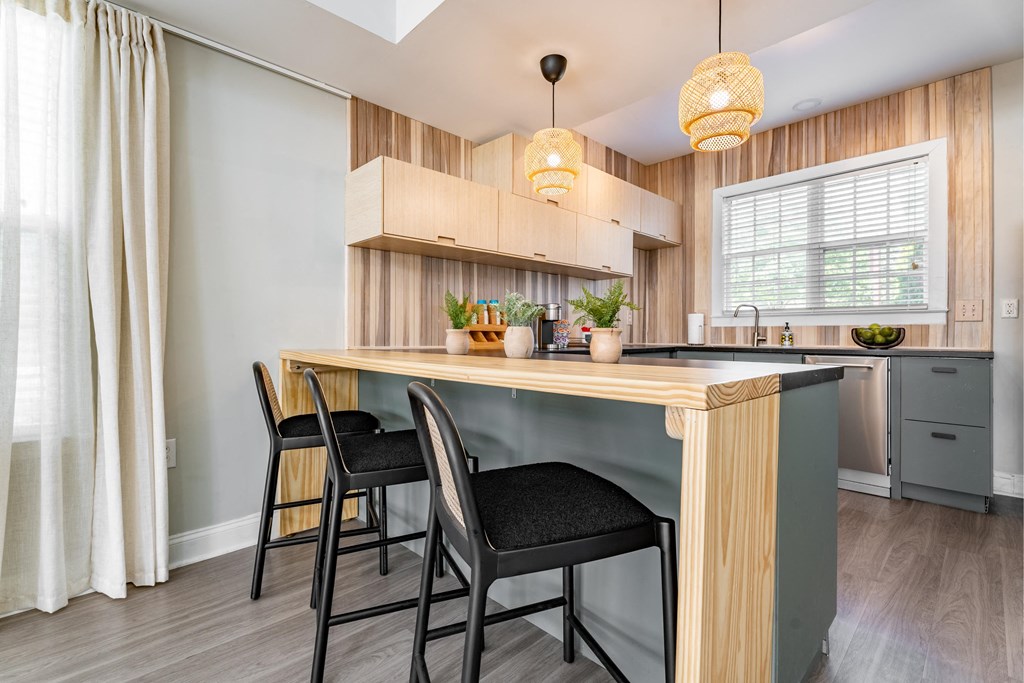 a kitchen with a bar and three stools