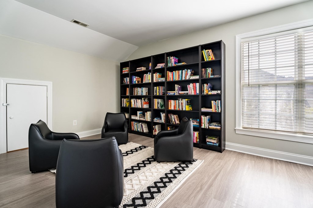 a living room with chairs and a bookshelf filled with books