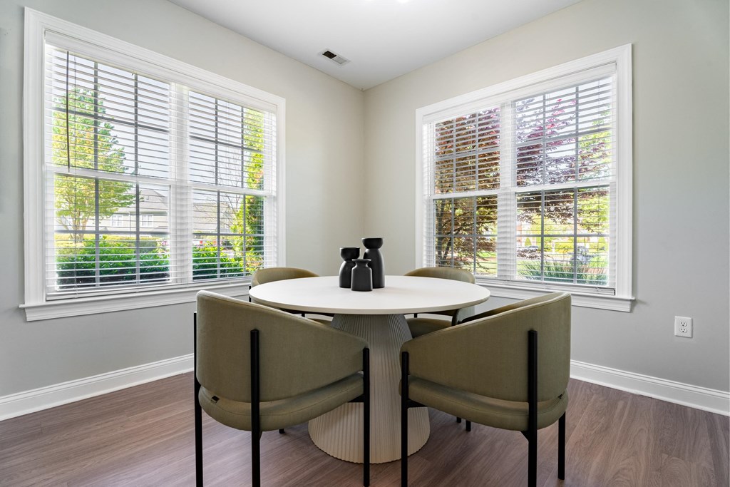 a dining room with two windows and a table and chairs