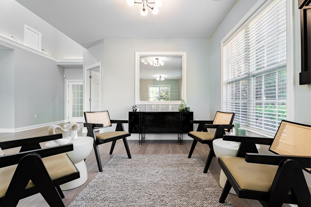 a living room with white walls and a black table and chairs