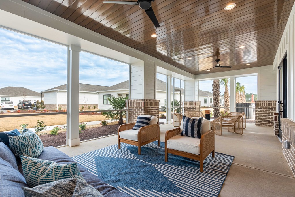 a covered porch with a couch and chairs