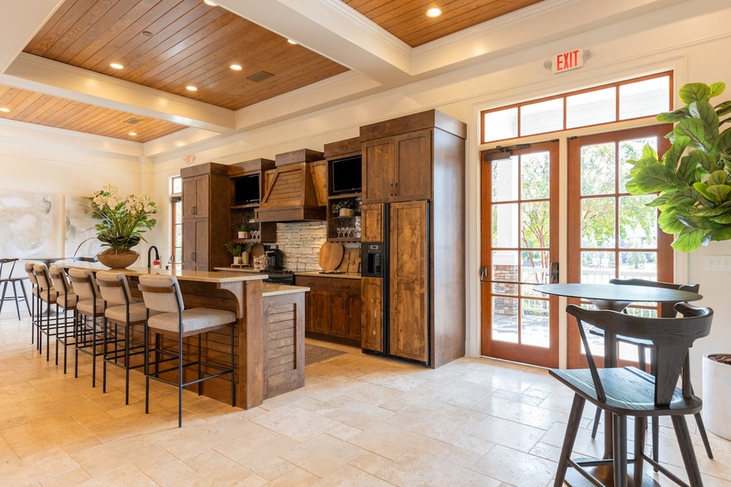 the kitchen has a large island with bar stools and a door to the patio