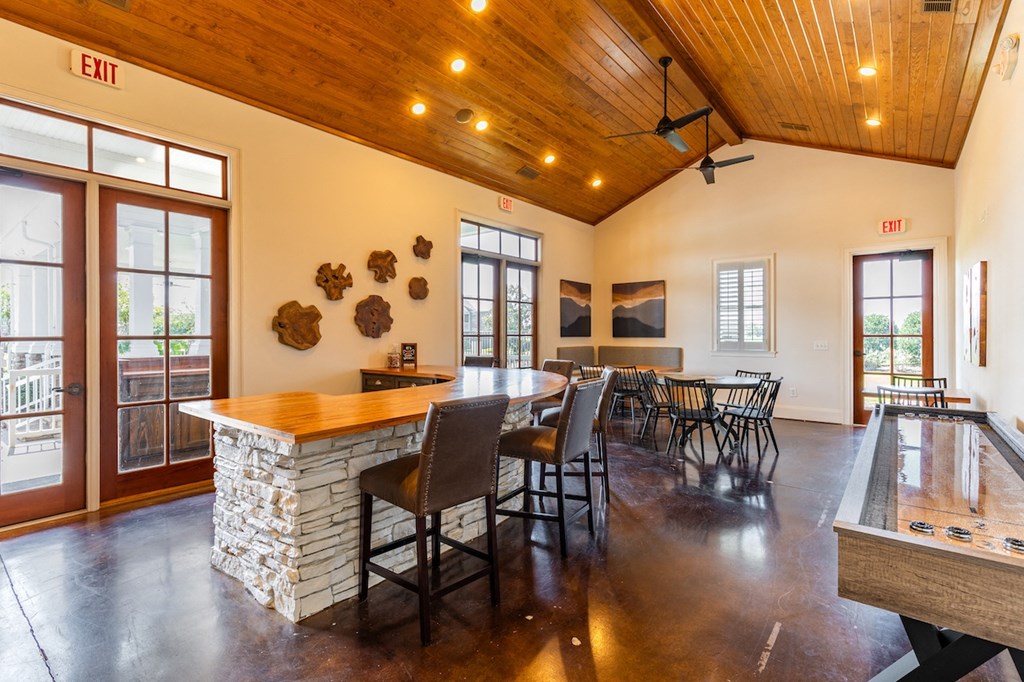 a large room with a bar and a table with chairs