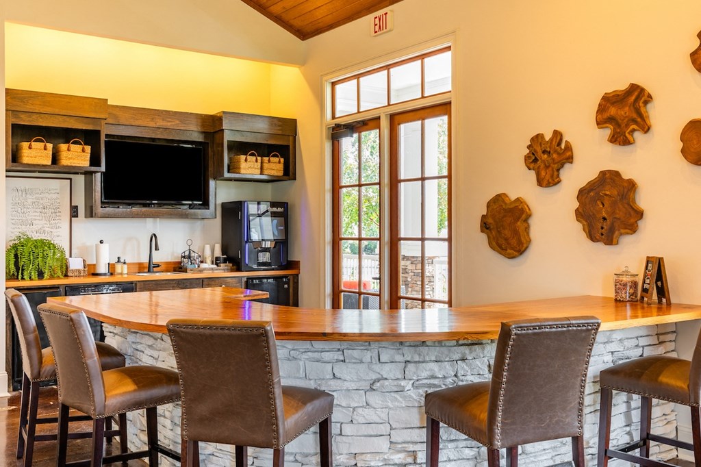 a kitchen with a bar and a counter with chairs
