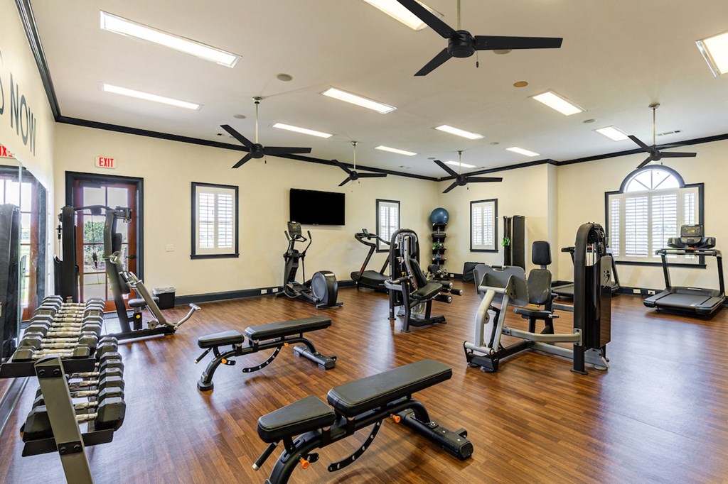 a gym with weights and other exercise equipment on a wooden floor