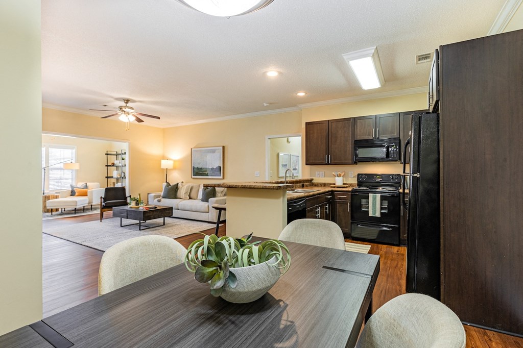 the view of a living room and kitchen with a table and chairs