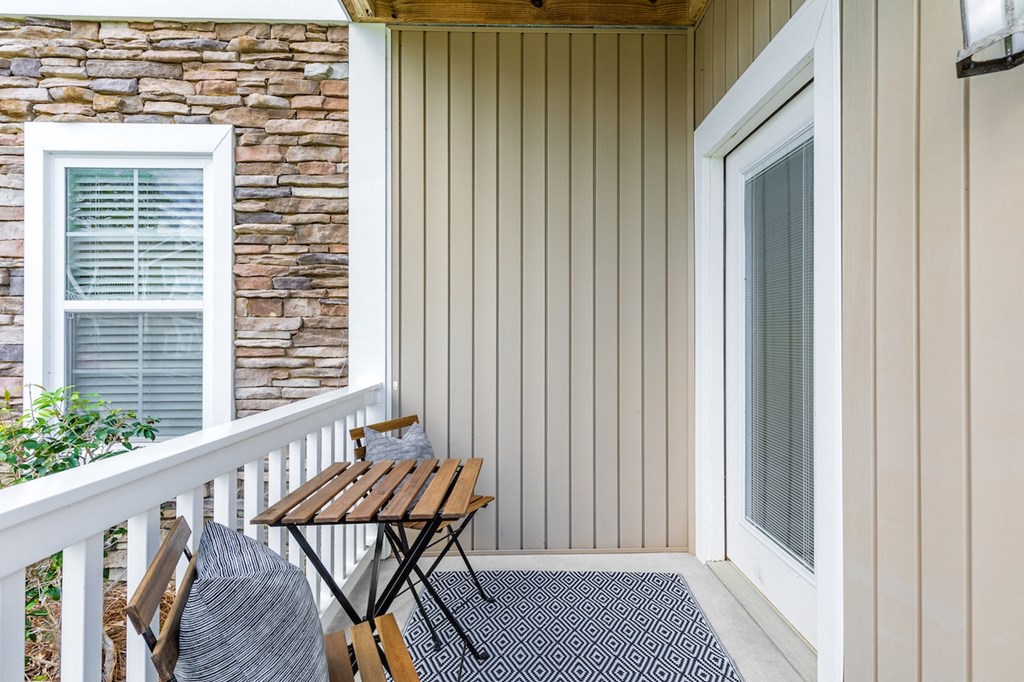 a porch with a table and chairs and a window