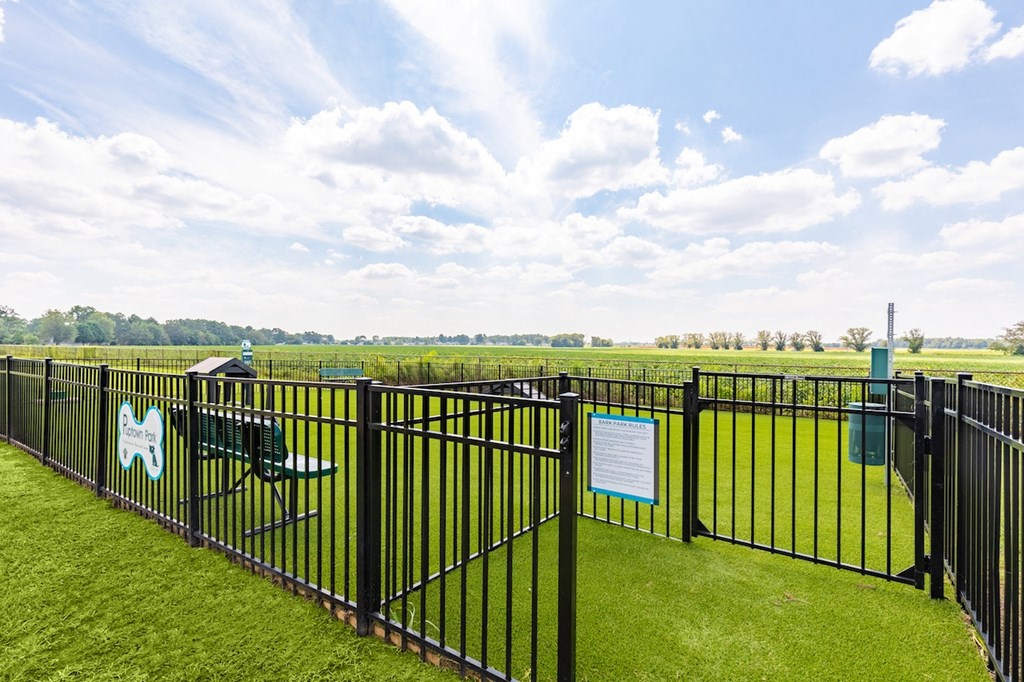a view of a park with a fence and a picnic table