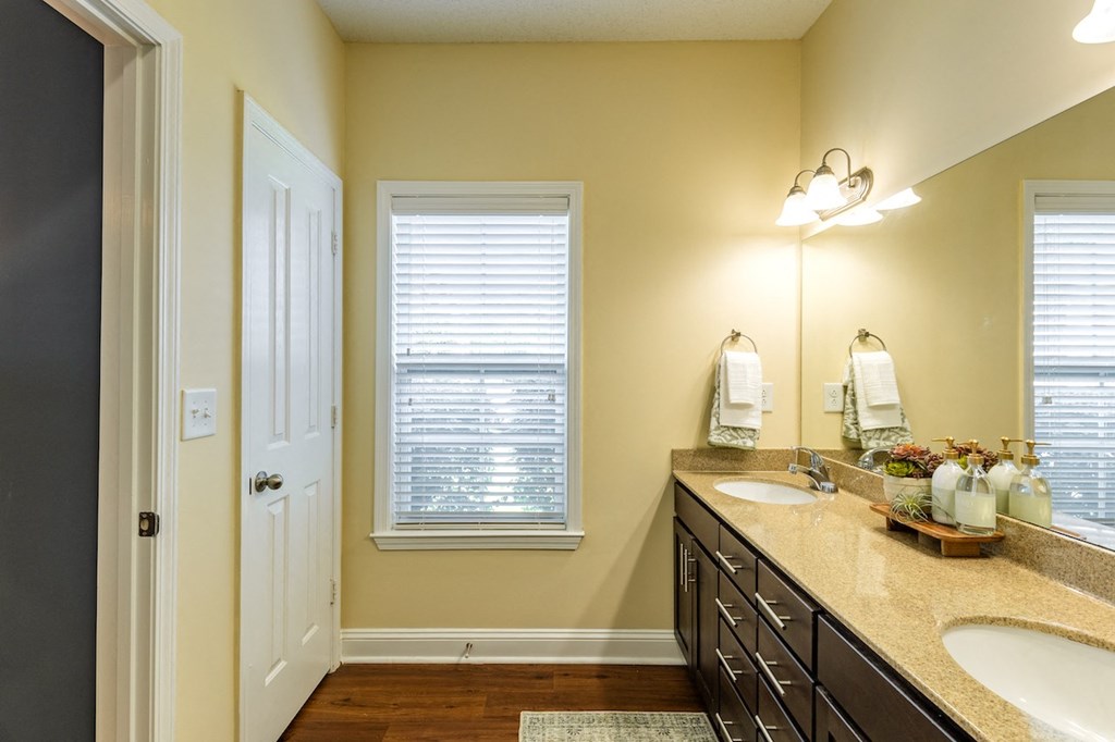 a bathroom with two sinks and a window and a door