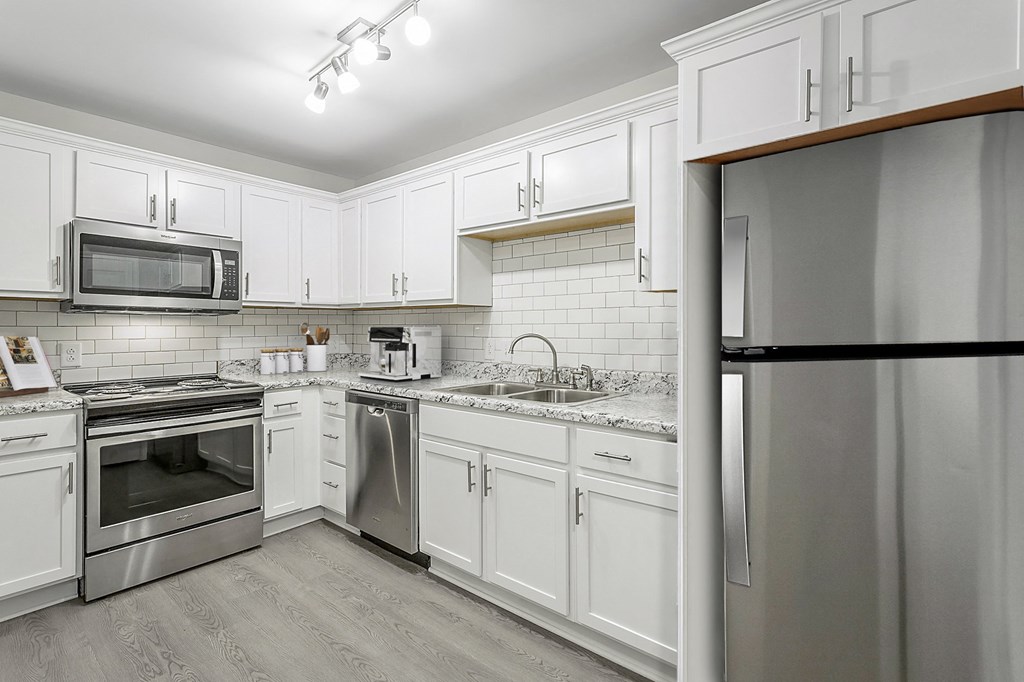 a kitchen with stainless steel appliances and white cabinets