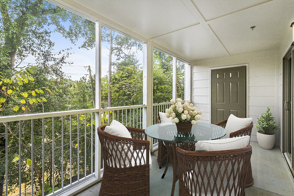 a patio with a glass table and chairs on it