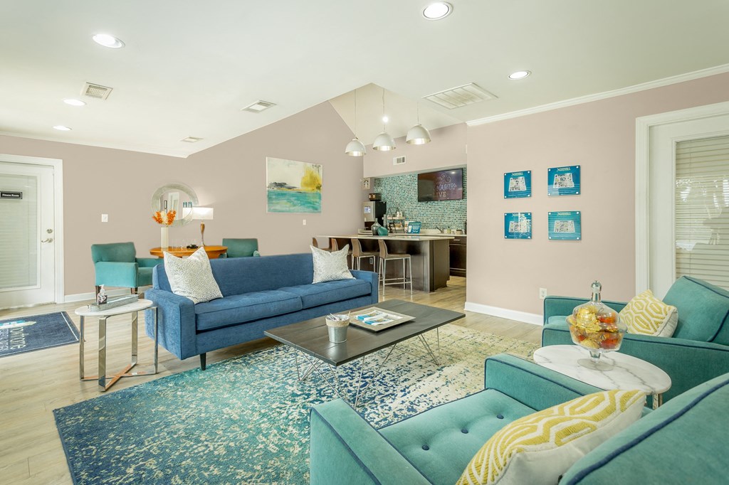 a living room with blue couches and chairs and a rug