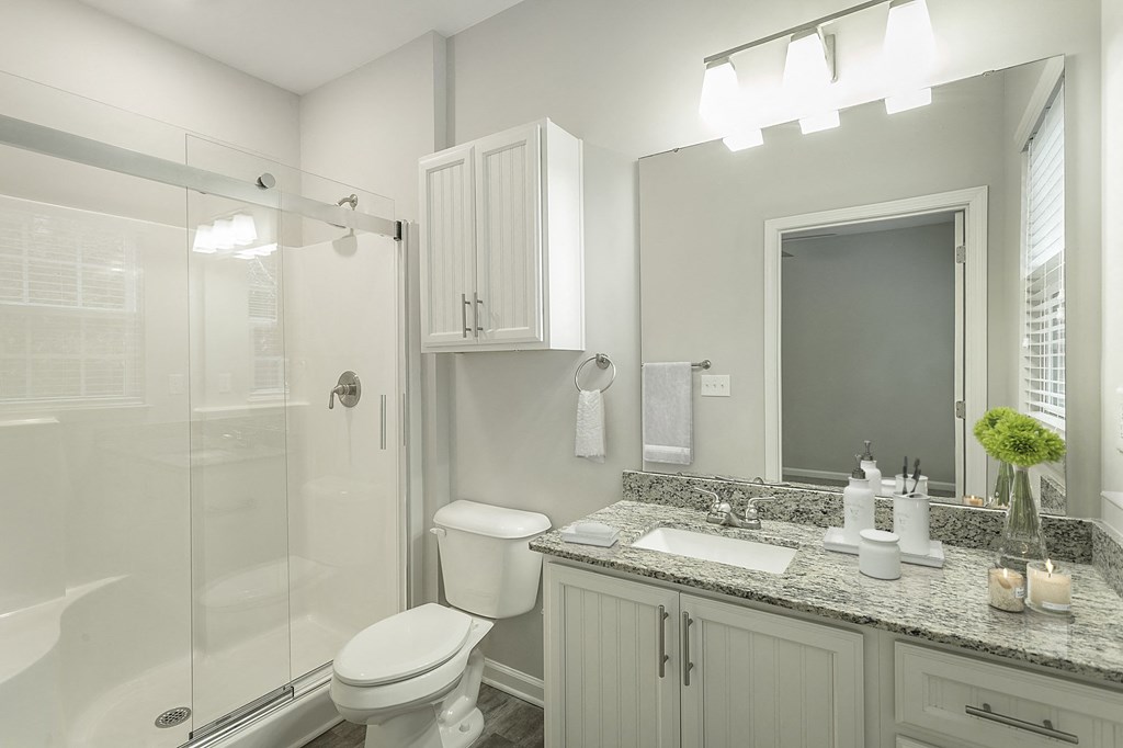 a white bathroom with a shower and a sink