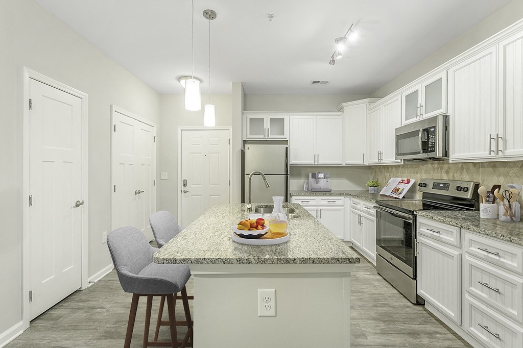 a kitchen with white cabinets and a granite counter top