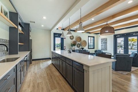 a kitchen with a large island and a living room with a table and chairs
