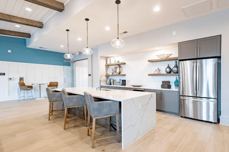 a large kitchen with stainless steel appliances and a marble counter top