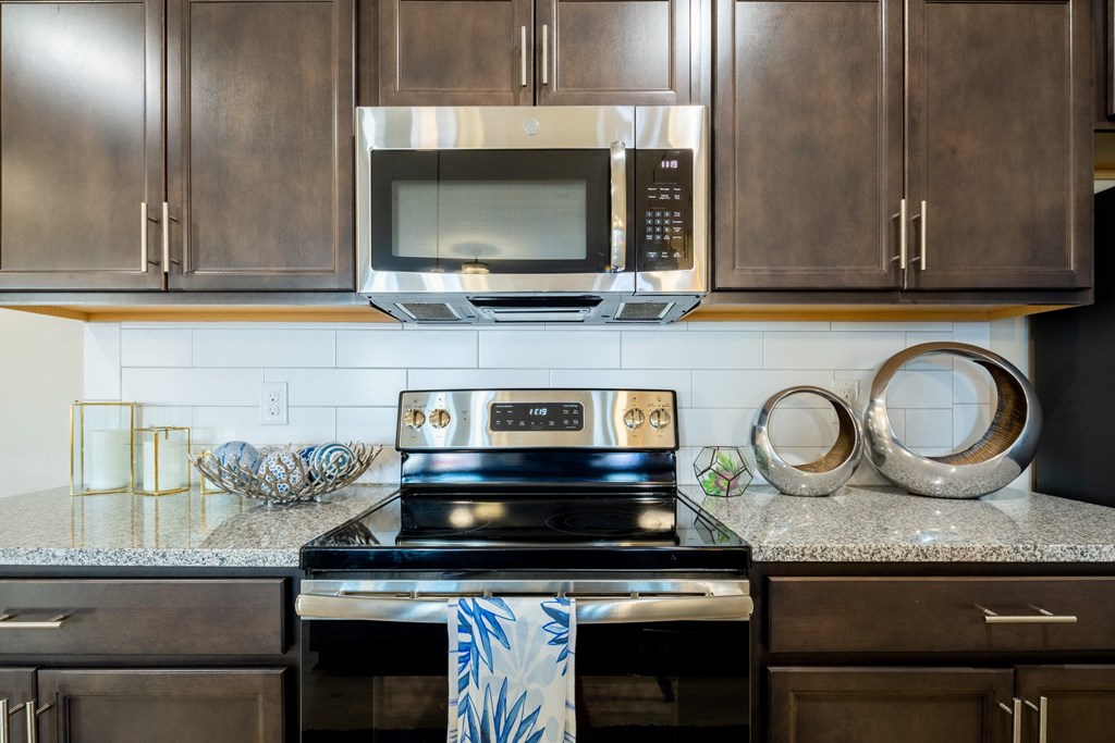 an updated kitchen with stainless steel appliances and granite counter tops