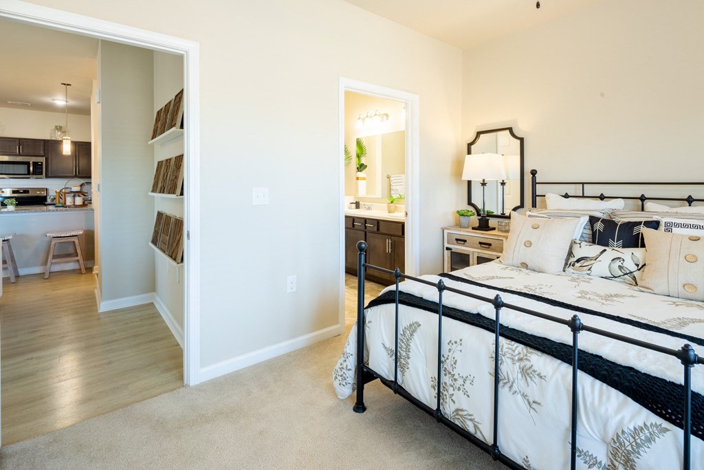 a bedroom with a bed and a closet and a kitchen