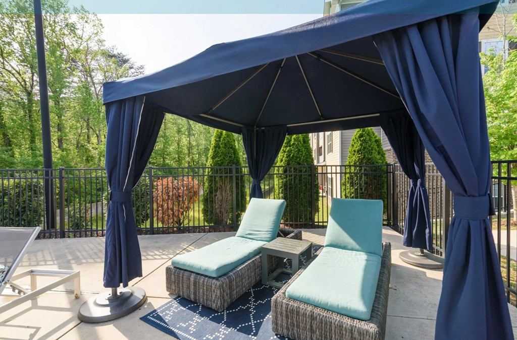 A blue canopy is over a patio with two chairs and a table at Hawthorne at the Hollow apartments in Soddy-Daisy, TN.