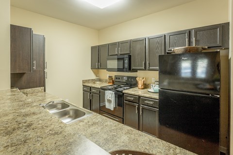 a kitchen with black appliances and granite counter tops