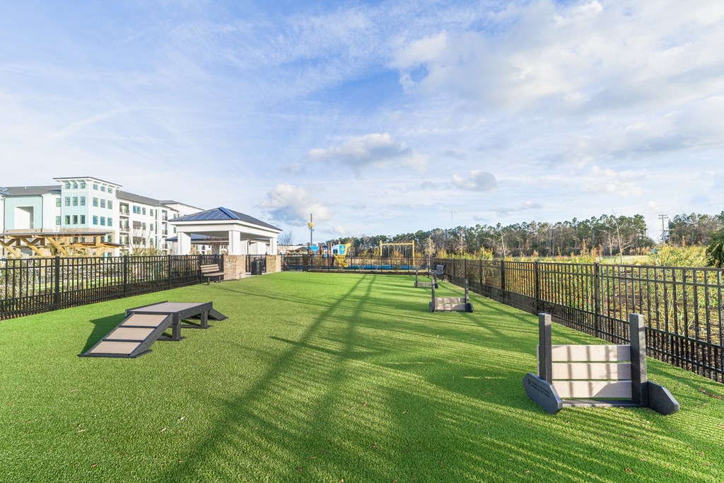 a large grassy area with benches and a fence