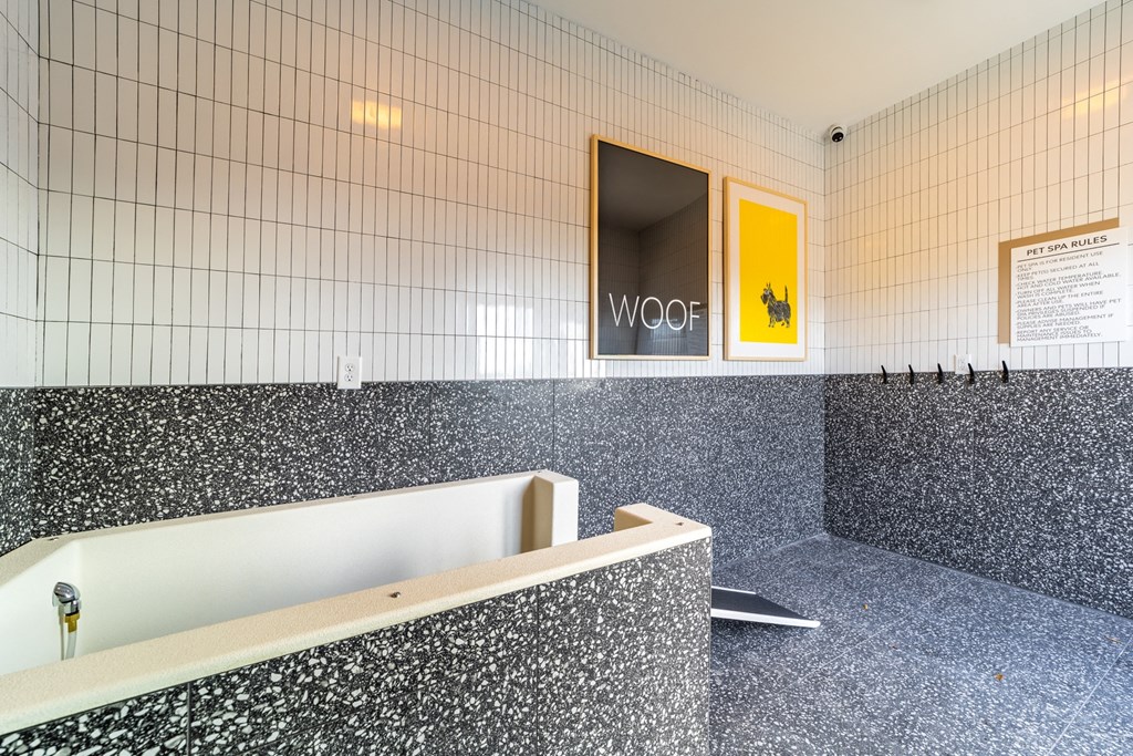 a large white tub in a room with white tiled walls