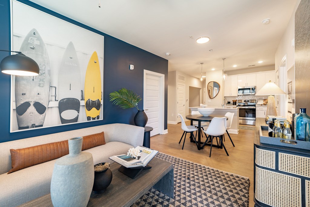 a living room with a couch and a table in front of a kitchen