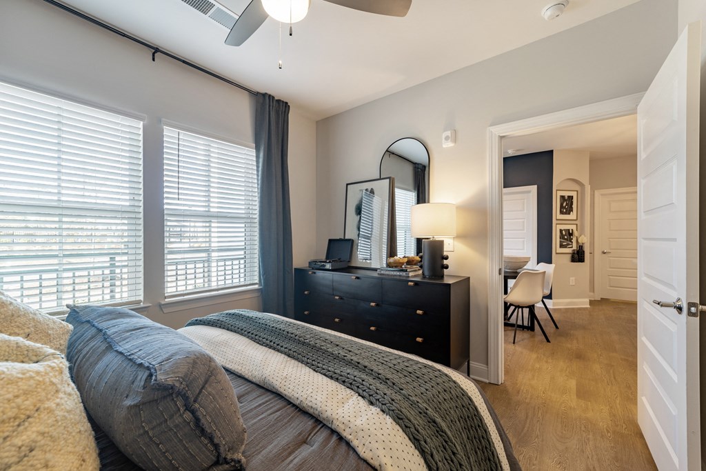 a bedroom with a bed and a dresser with a mirror