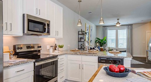 a large kitchen with a bowl of fruit on the counter