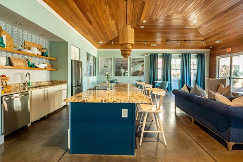 a kitchen with a blue island and a living room with a couch and a bar