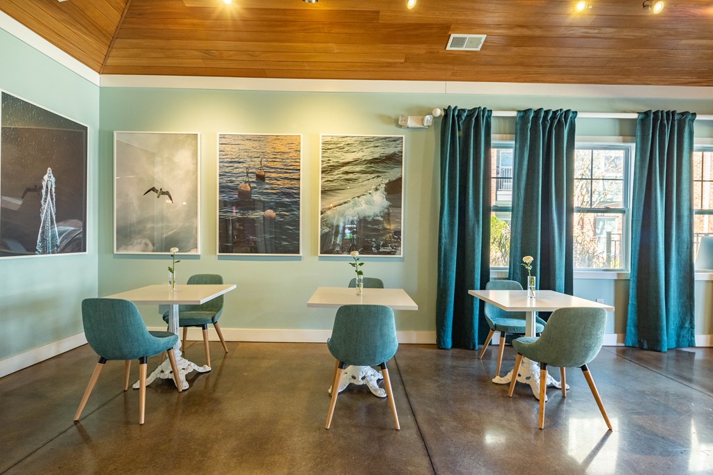 a dining room with tables and chairs and pictures on the wall