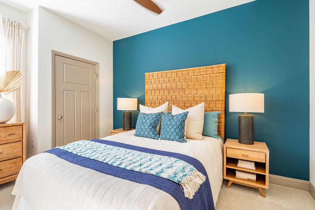 a bedroom with a blue wall and a bed with pillows
