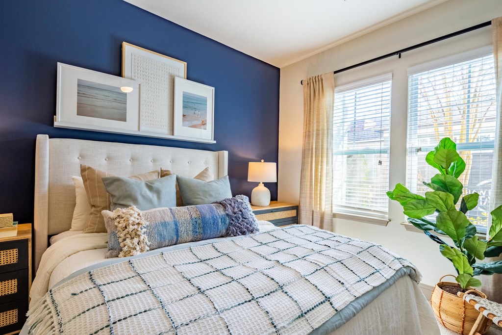 a bedroom with blue walls and a bed with pillows