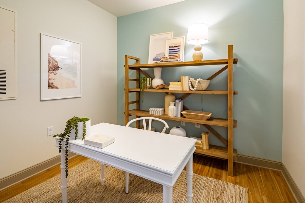 a home office with a white desk and a shelf