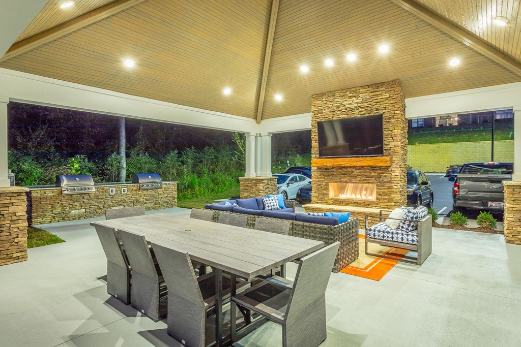 a patio with a table and chairs and a fireplace