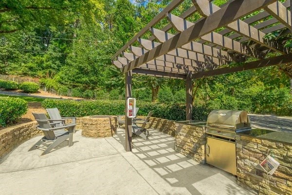 a patio with a barbecue grill and a pergola