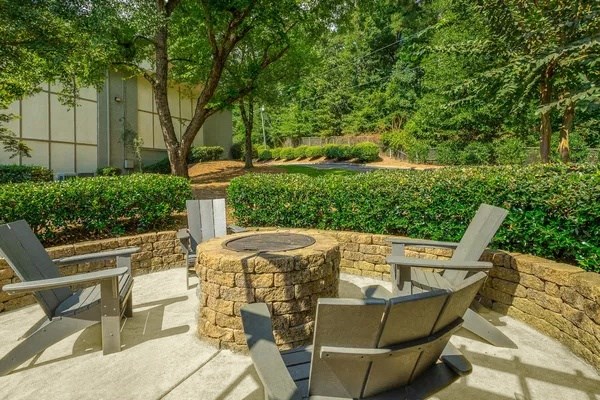 a patio with chairs and a fire pit