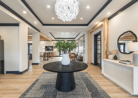 a living room with a round table and a chandelier
