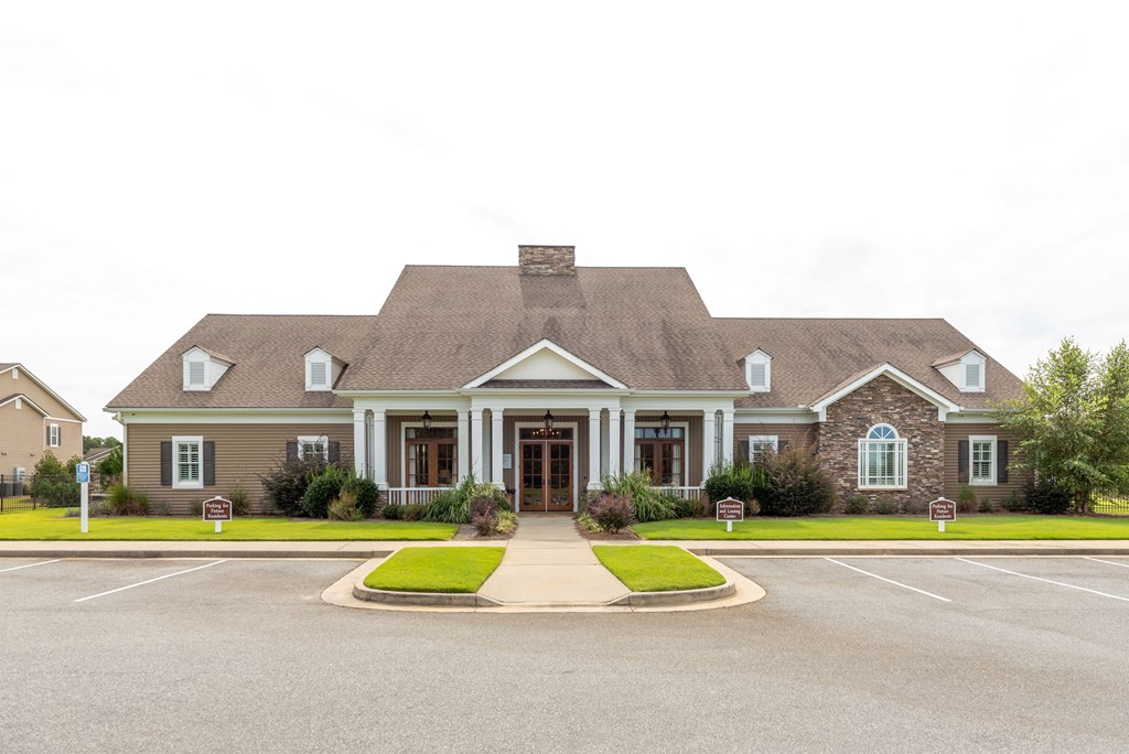 the front of a house with a driveway and lawn