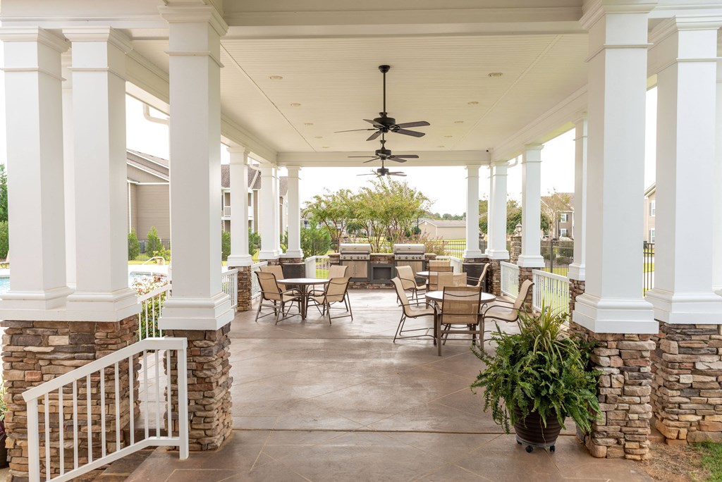 the back porch of a home with tables and chairs on it