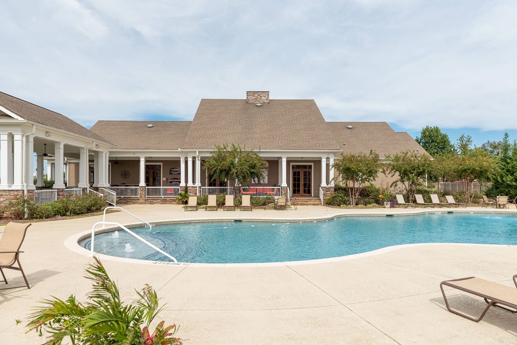 a swimming pool with a house in the background