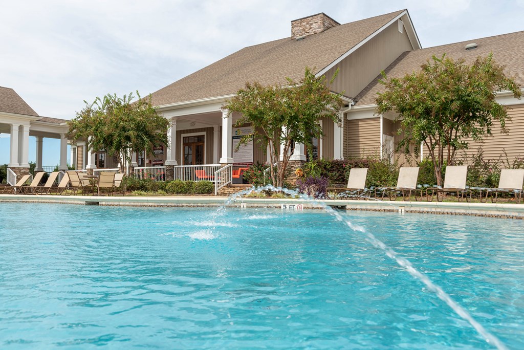 a large swimming pool with a house in the background