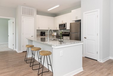 a kitchen with an island and three stools