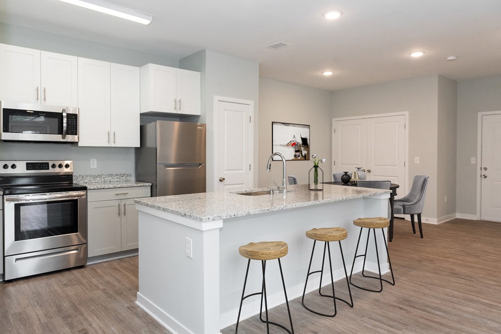 a kitchen with a large center island with three stools in front of it