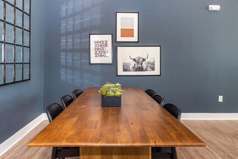 a conference room with a wooden table and chairs and pictures on the wall
