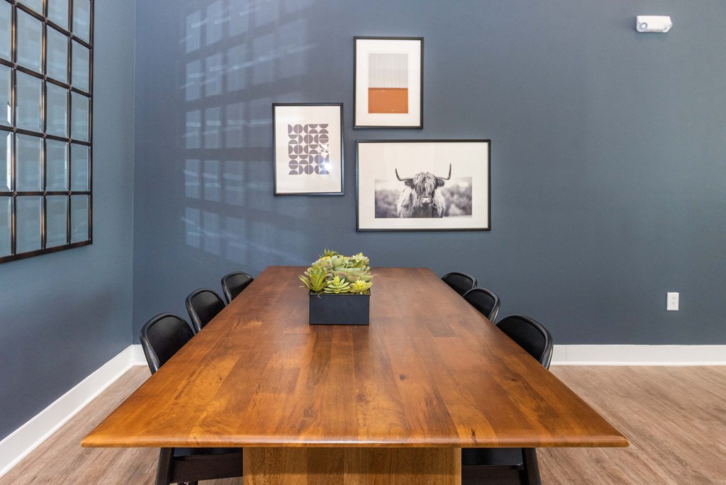 a conference room with a wooden table and chairs and pictures on the wall