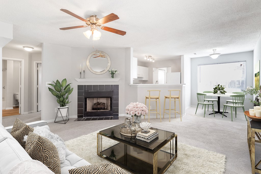 a living room with a fireplace and a ceiling fan